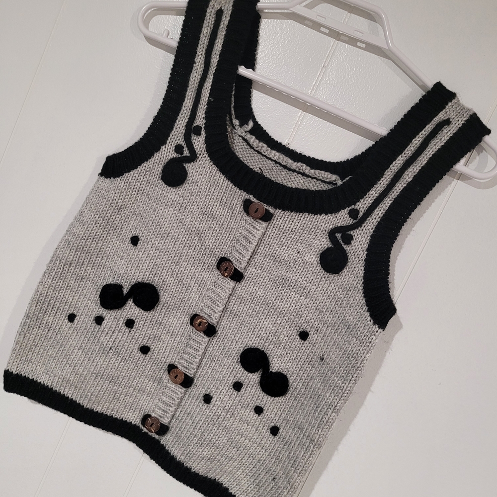 Gray Knit Vest With Black Accents And Brown Buttons.